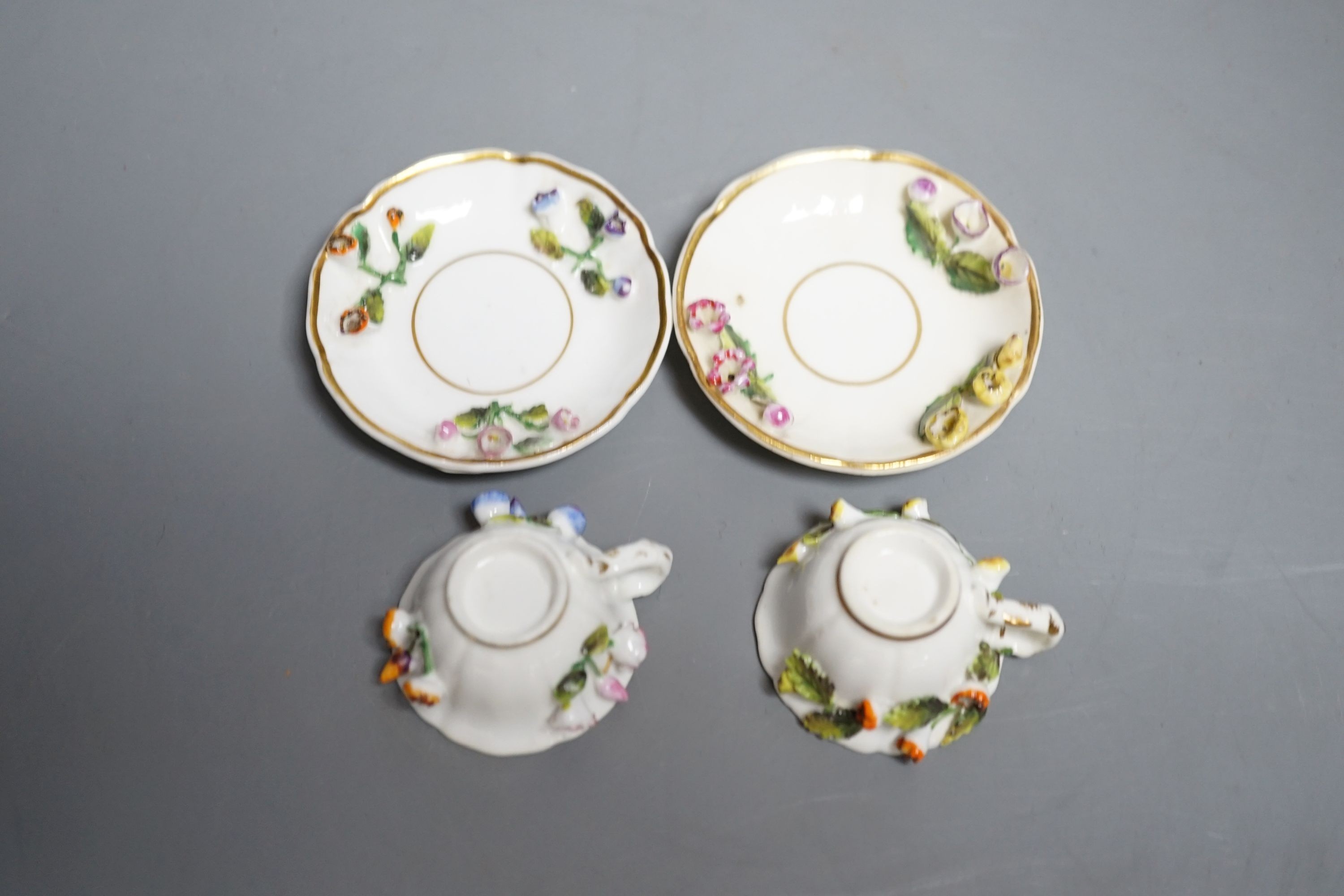 Two Rockingham miniature flower encrusted cups and saucers, c.1830. Provenance - Mona Sattin collection of miniature cups and saucers, collection no. 199 and 200.